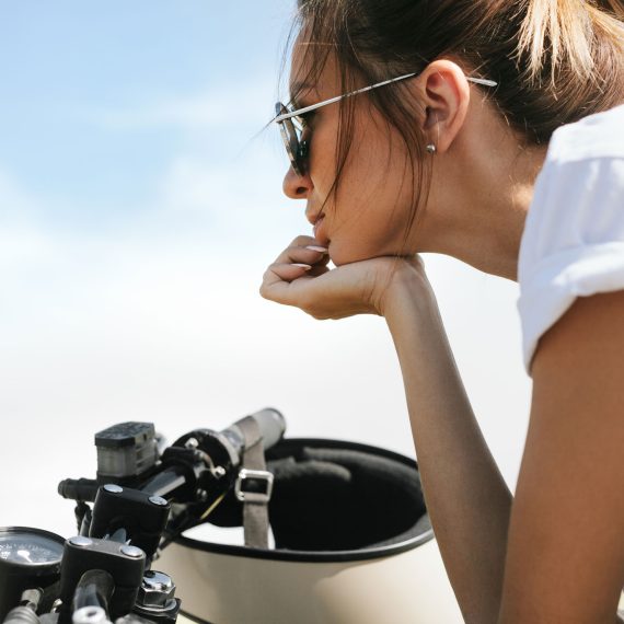 biker-girl-sitting-on-vintage-custom-motorcycle-PRER32L.jpg